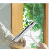 A hand is using a white multi-function glass cleaner and scraper to wipe a window, leaving a clean surface.