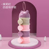 A stack of four purple and pink silicone food storage boxes for baby snacks.