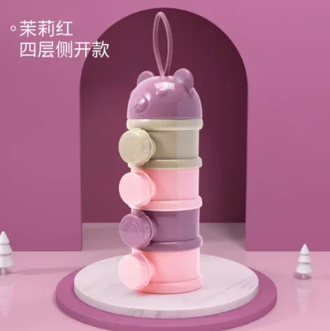 A stack of four purple and pink silicone food storage boxes for baby snacks.