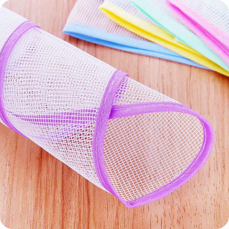 Un rouleau de tamis de protection anti-chaleur violet à côté de plusieurs bandes de tissu colorées sur une surface en bois.