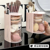 A pink acrylic rotating organizer holds various makeup brushes and hair accessories.