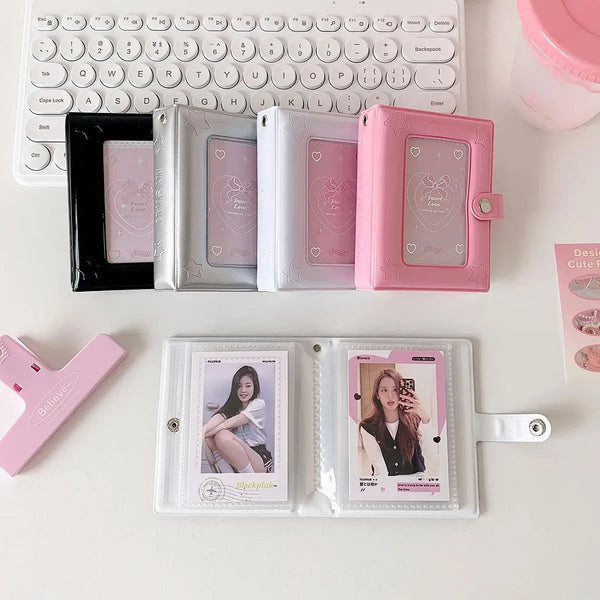 Eine Sammlung quadratischer Fotoalben und Karten in rosa und silbernen Tönen auf einer weißen Oberfläche.