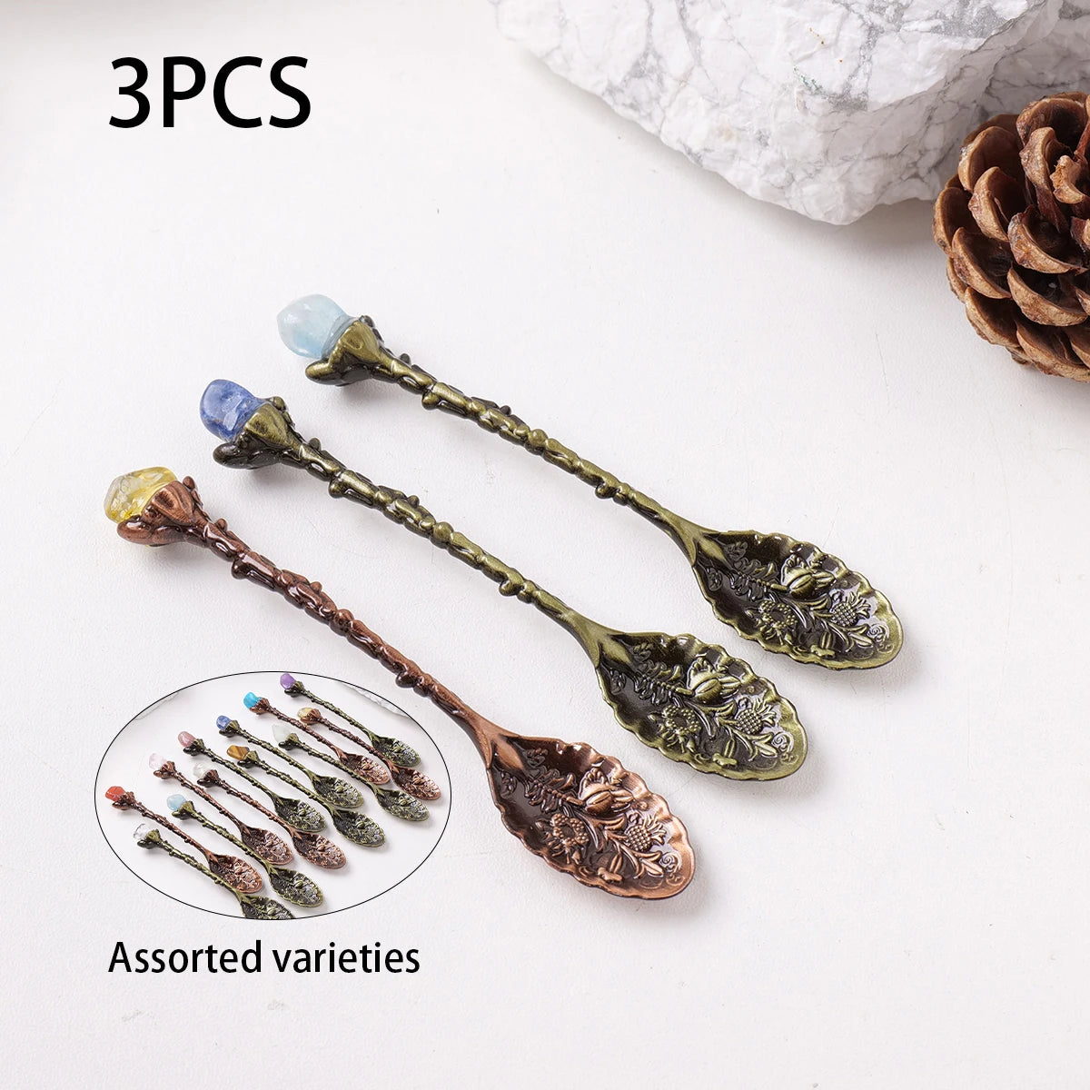 Three assorted natural crystal spoons with blue and green stones displayed on a white background.