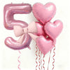 Un set de seis globos de látex en forma de corazón rosa, incluyendo el número '5', atados con cintas rosas y rojas.