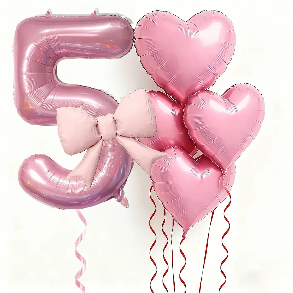 Un set de seis globos de látex en forma de corazón rosa, incluyendo el número '5', atados con cintas rosas y rojas.