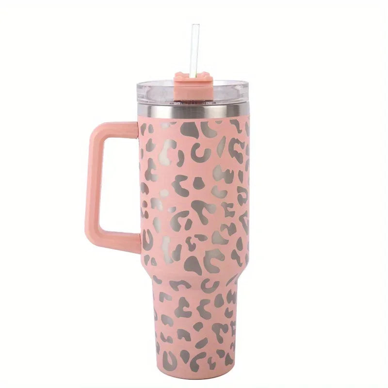 A pink leopard print insulated stainless steel tumbler with a handle and straw.