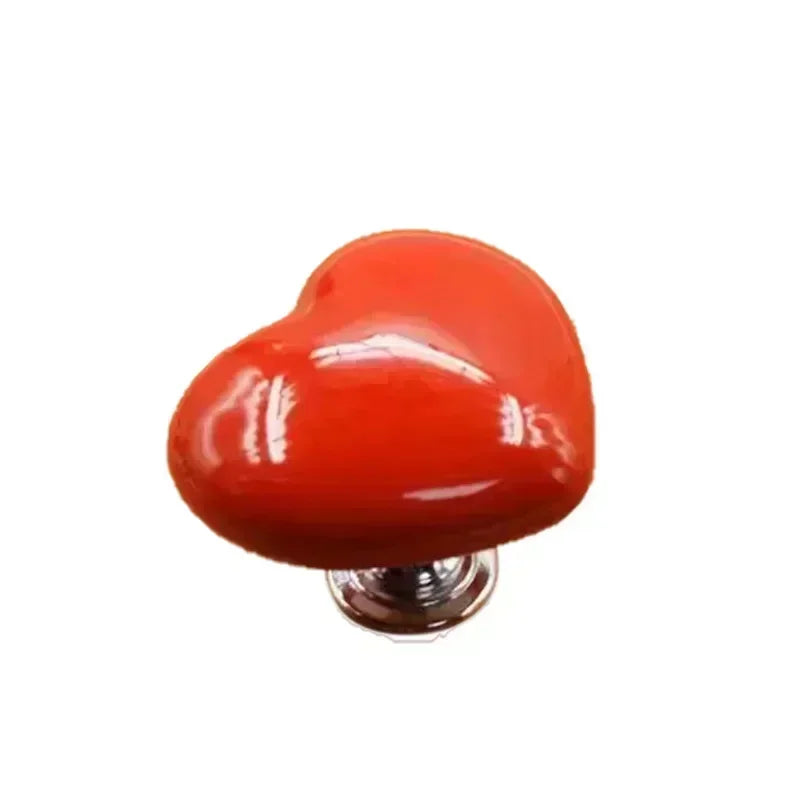 A glossy, heart-shaped toilet presser button in bright orange.