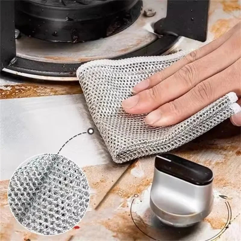A hand holds a mesh steel wire cleaning cloth, demonstrating its texture and use for cleaning.