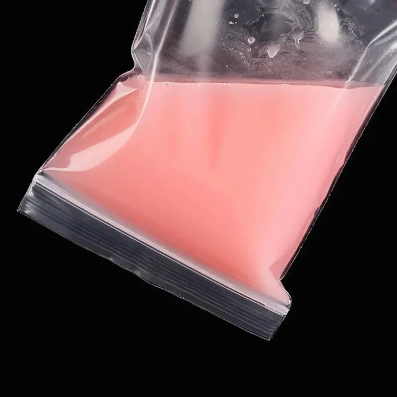 Una bolsa ziplock transparente llena de líquido rosa, vista desde arriba.