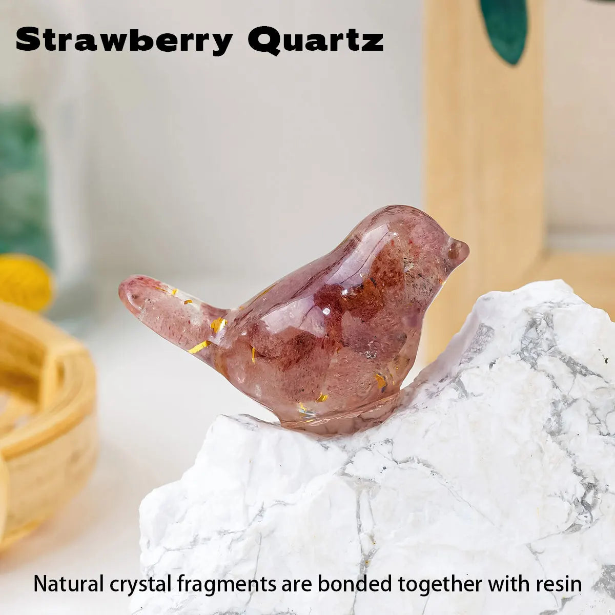 A pink strawberry quartz crystal bird statue resting on a white marble surface.