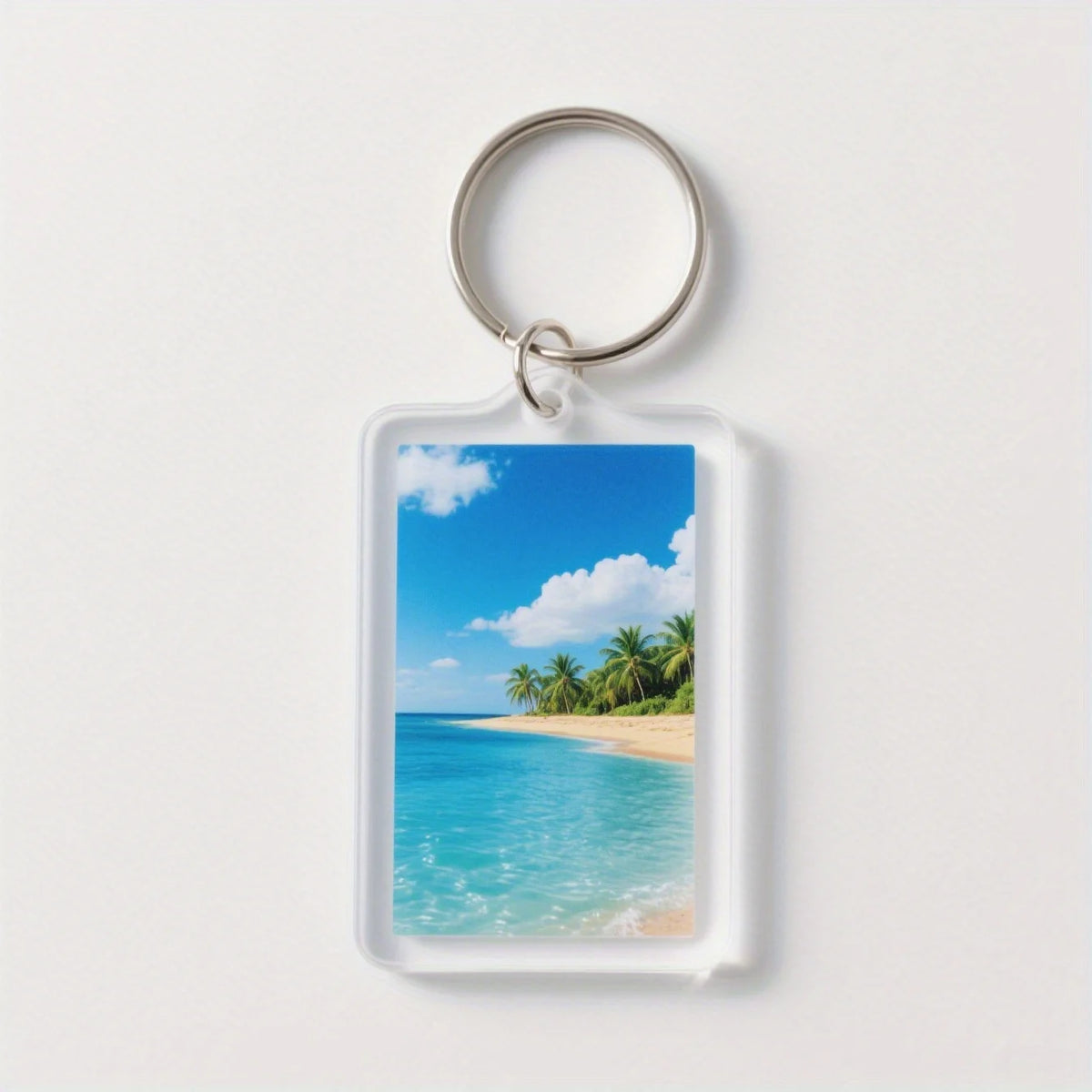 Clear acrylic keychain featuring a vibrant tropical beach scene with blue water and palm trees under a bright sky