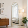 A full body wall mirror with an aluminum frame reflecting a bright room and a window.