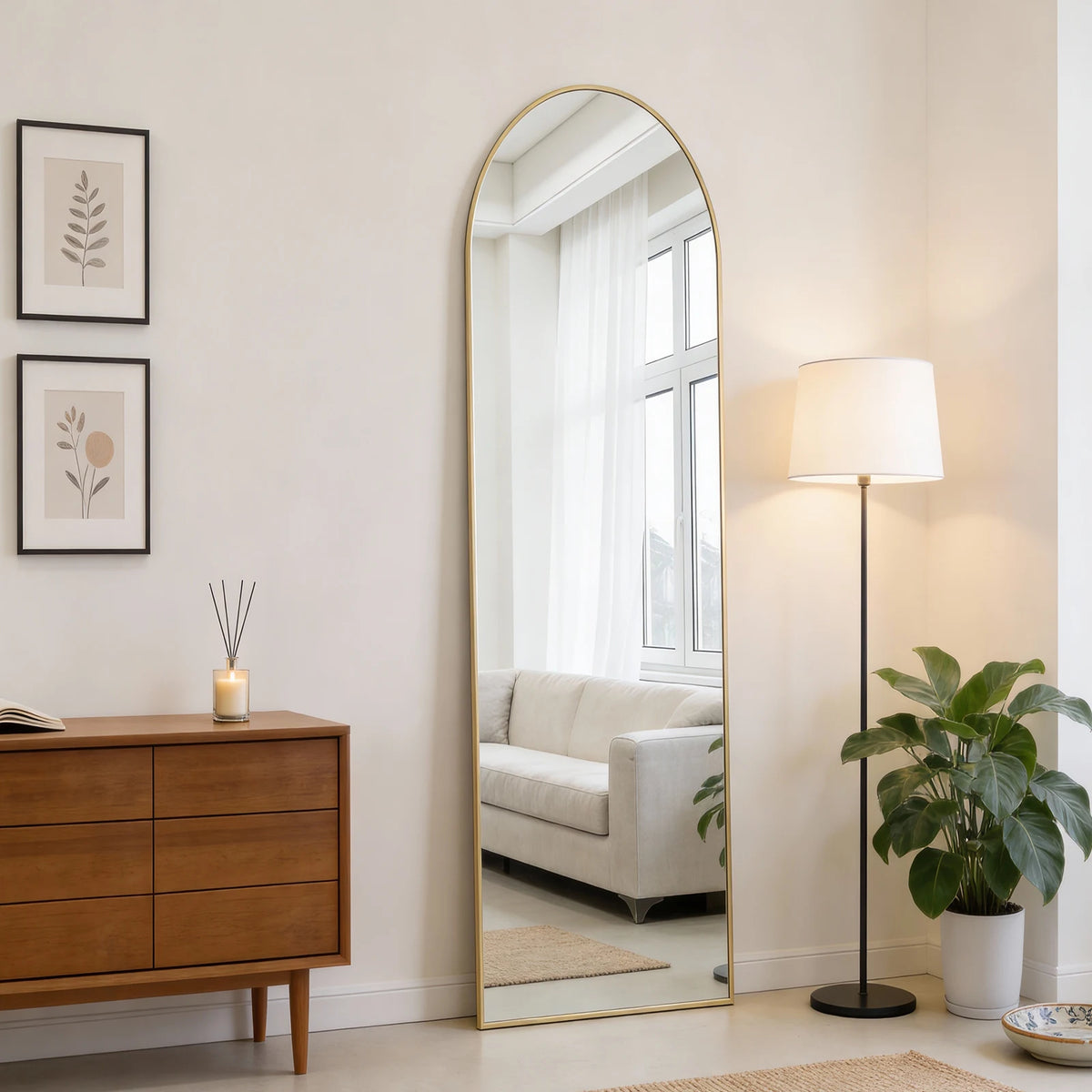 A full body wall mirror with an aluminum frame reflecting a bright room and a window.
