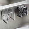 Stainless steel sponge holder rack with suction cup mounted on a surface.