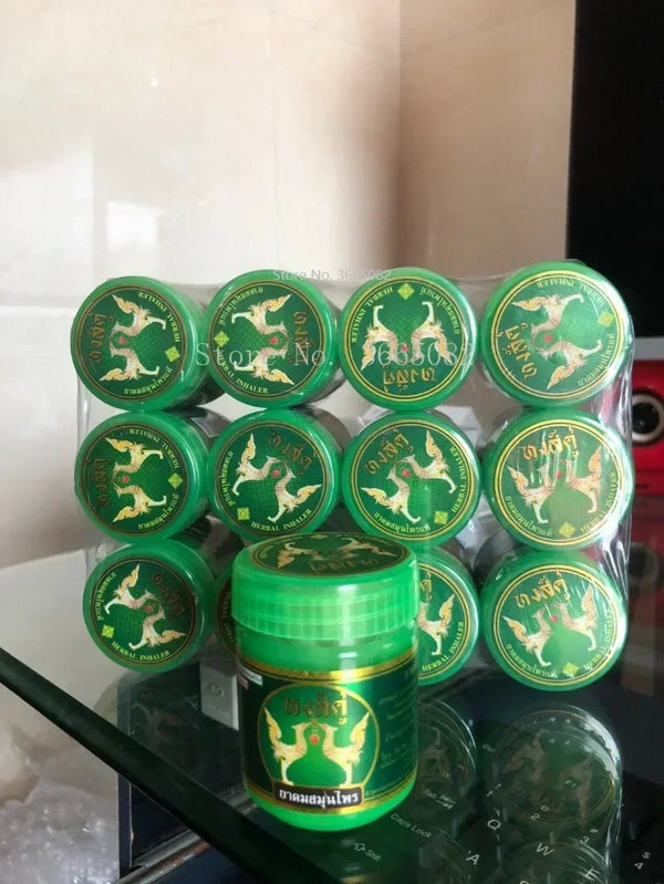 A clear plastic container holds multiple green glass jars of traditional herbal inhalers for congestion relief.