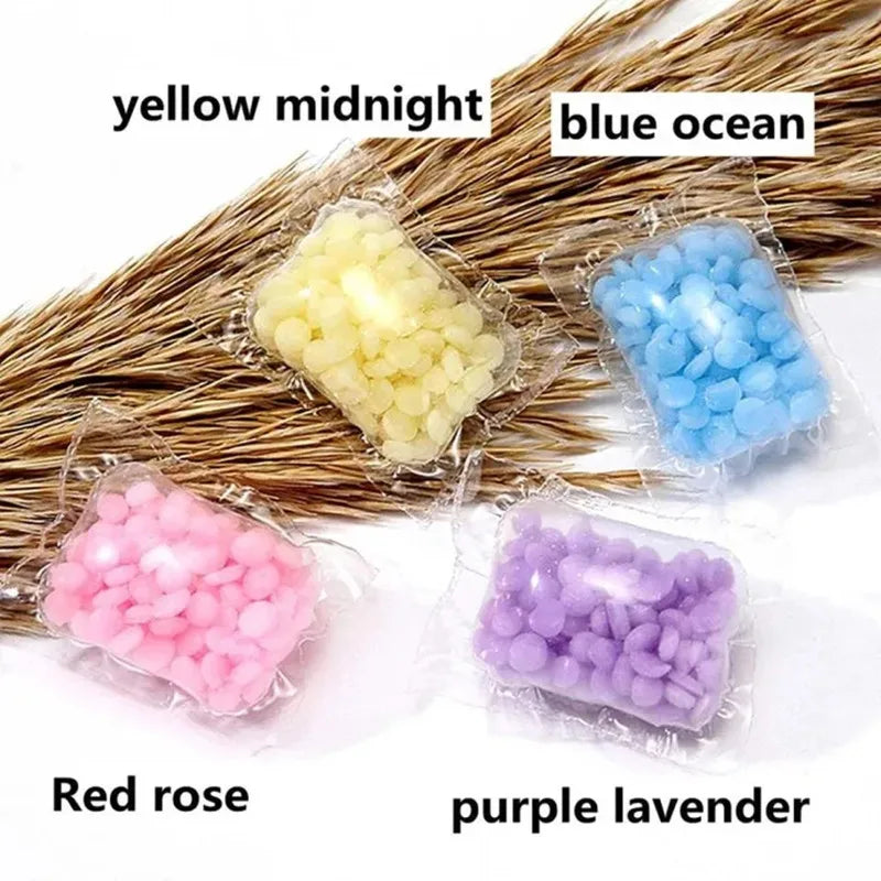 Assortment of laundry fragrance beads in yellow midnight, blue ocean, red rose, and purple lavender packaged in clear plastic