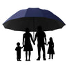 Ein schwarzer Regenschirm ist geöffnet und schützt eine vierköpfige Familie unter dem Baldachin.