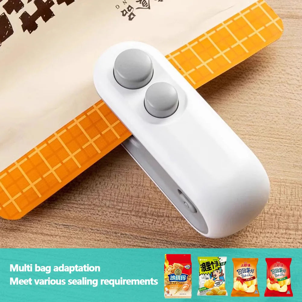A white handheld bag sealer and cutter with an orange grip, shown on a light wooden surface.