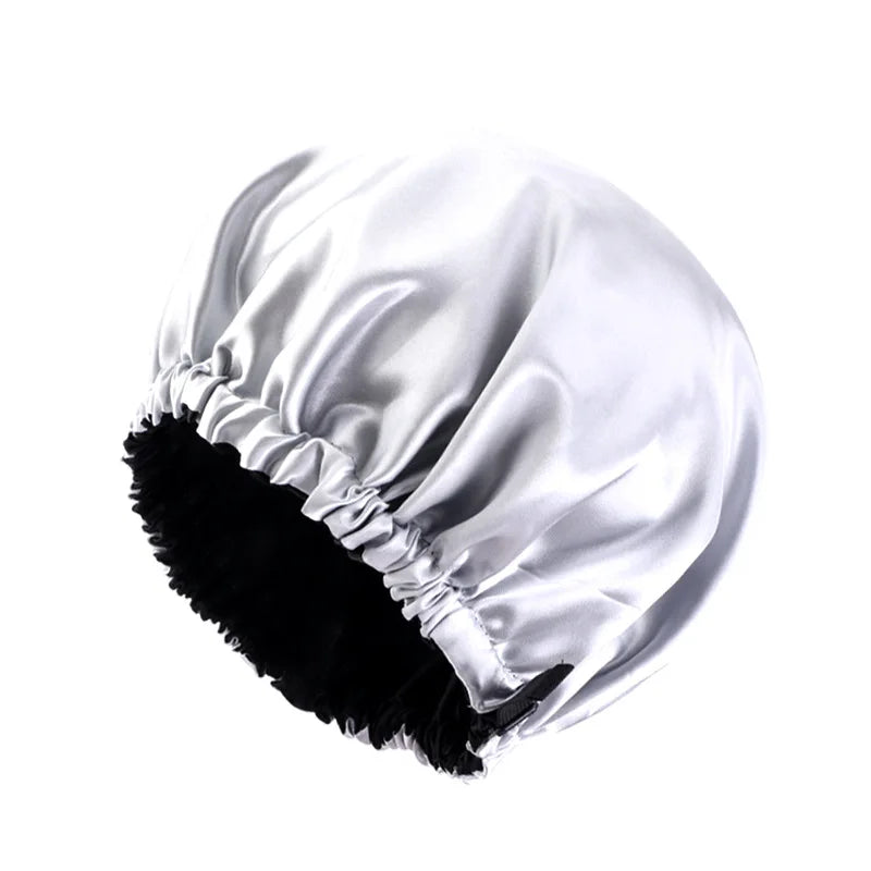 A silver satin sleep cap with ruffled edges is shown against a white background.
