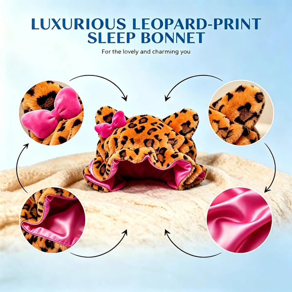 A luxurious leopard-print sleep bonnet with pink satin trim shown on a fluffy white surface.