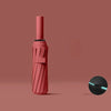 A pink heavy-duty automatic windproof umbrella with a textured handle and black cap.