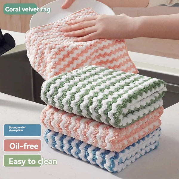 A stack of coral and green velvet cleaning cloths is shown next to a hand, highlighting strong water absorption, oil-free pro