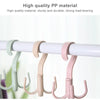 A set of light pink and mint green plastic hooks used for hanging clothes on a white rod.