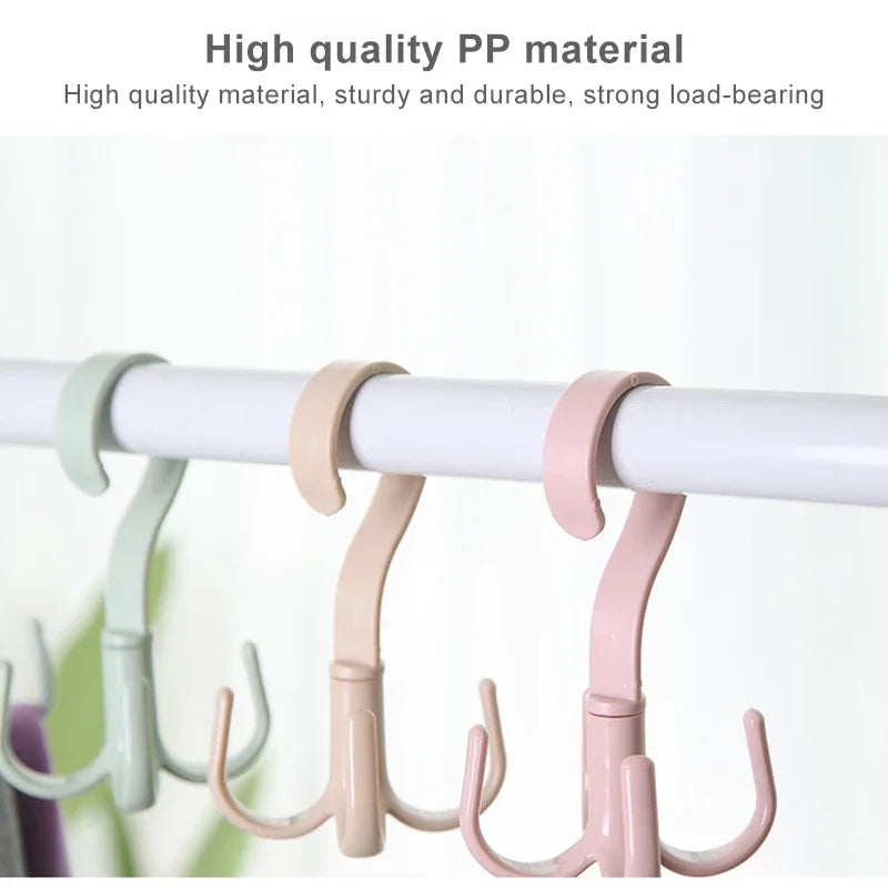 A set of light pink and mint green plastic hooks used for hanging clothes on a white rod.