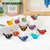 A collection of colorful crystal bird statues in various shades displayed on a white surface.