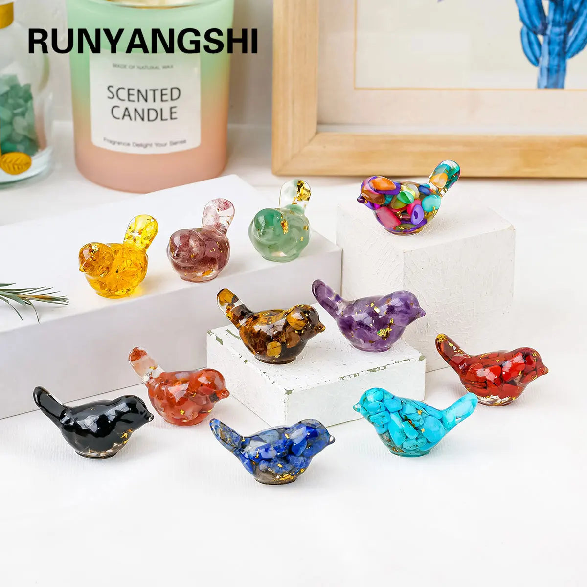 A collection of colorful crystal bird statues in various shades displayed on a white surface.
