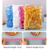 A clear plastic bag filled with pink, white, and yellow shower caps showing natural and stretch lengths.