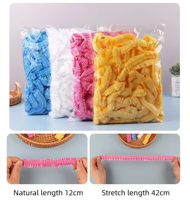 A clear plastic bag filled with pink, white, and yellow shower caps showing natural and stretch lengths.