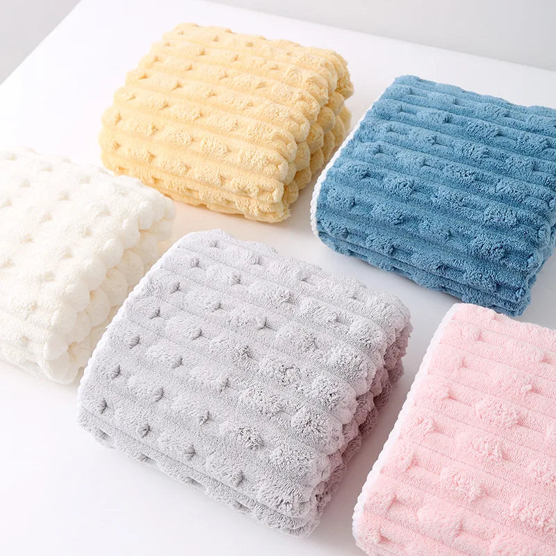 A collection of textured bath towels in yellow, blue, gray, and pink.