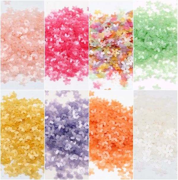 Colección de lentejuelas florales de 10mm coloridas en varios tonos: rosa, rojo, púrpura, amarillo y verde.