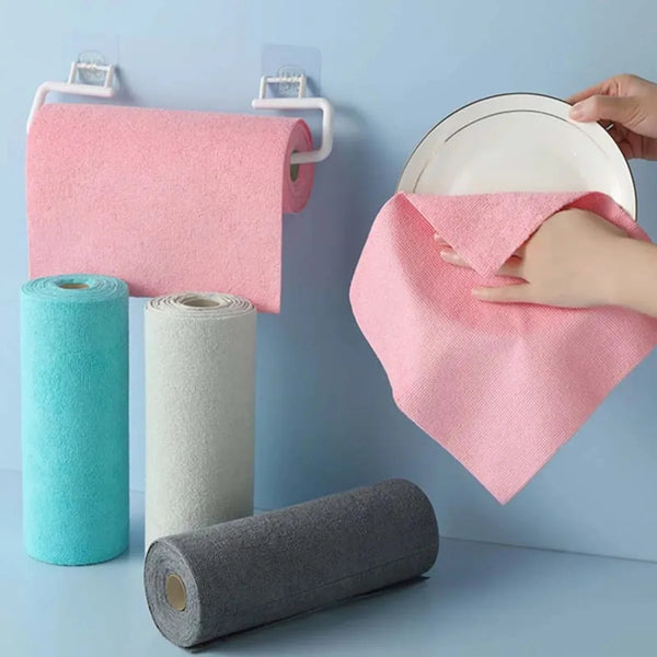 A pink microfiber cleaning cloth is hanging on a hook next to rolls of various colored cleaning cloths.