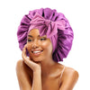 A woman wearing a purple satin sleeping cap tied in a bow, looking at the camera.