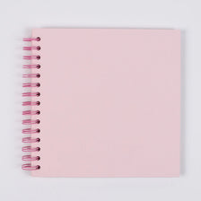 A blank pink spiral-bound notebook or scrapbook album.