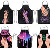 A set of black aprons featuring various nail-themed designs including handprints, glitter, and text like Pretty and Pink Nail