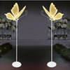Set romantischer Schmetterlings-LED-Bodenlampen mit goldenen Flügeln, die Blumenarrangements beleuchten.