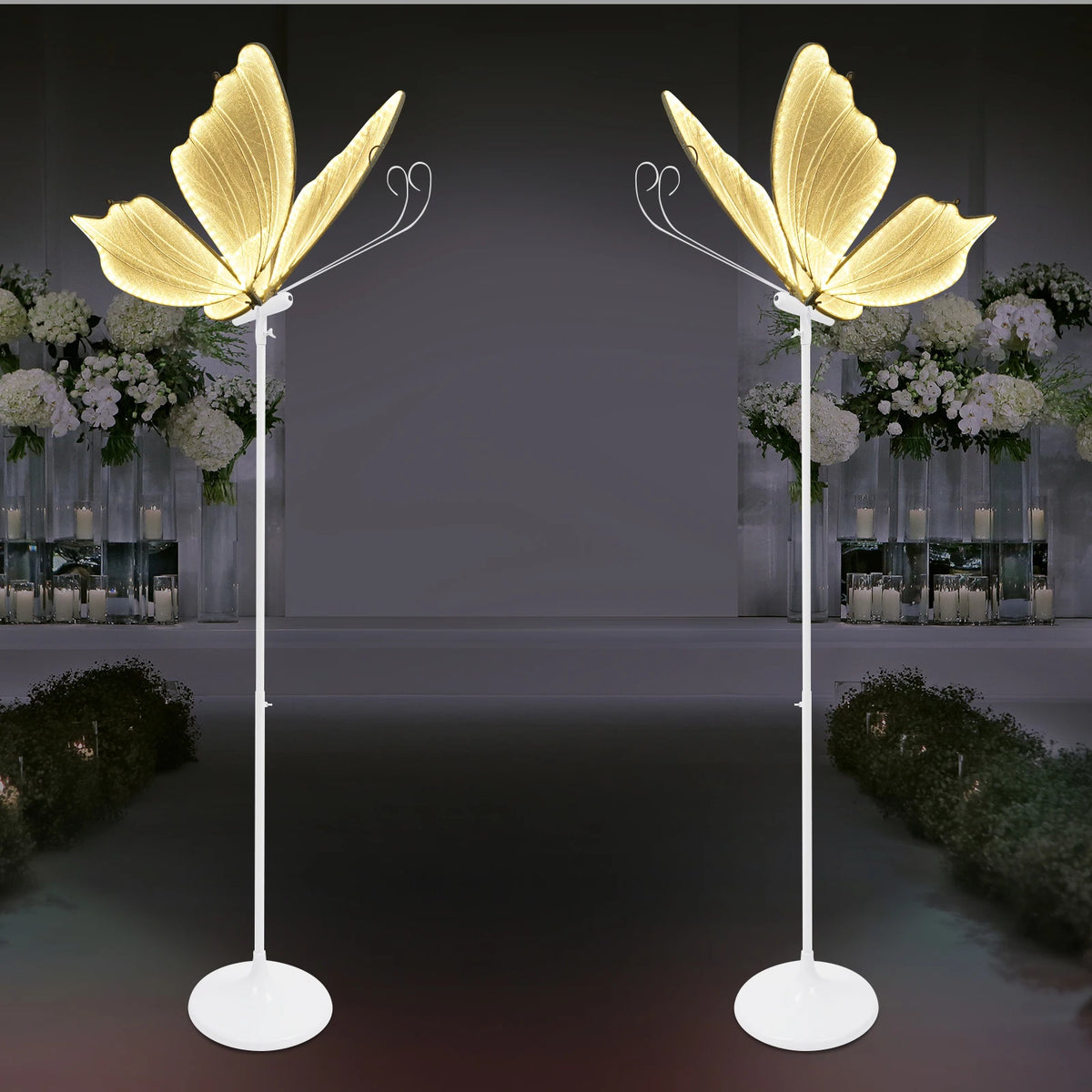 Set romantischer Schmetterlings-LED-Bodenlampen mit goldenen Flügeln, die Blumenarrangements beleuchten.