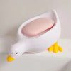 White duck-shaped soap dish with a pink soap bar on a white surface.