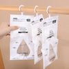 White mesh bags of moisture absorbent material are hanging on a wooden rod.