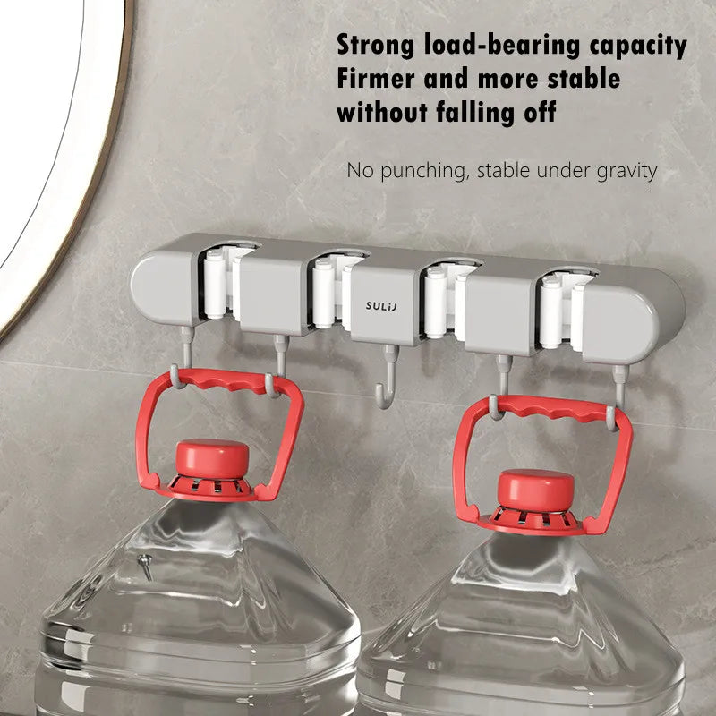 Wall mounted broom holder with red grips for kitchen or bathroom