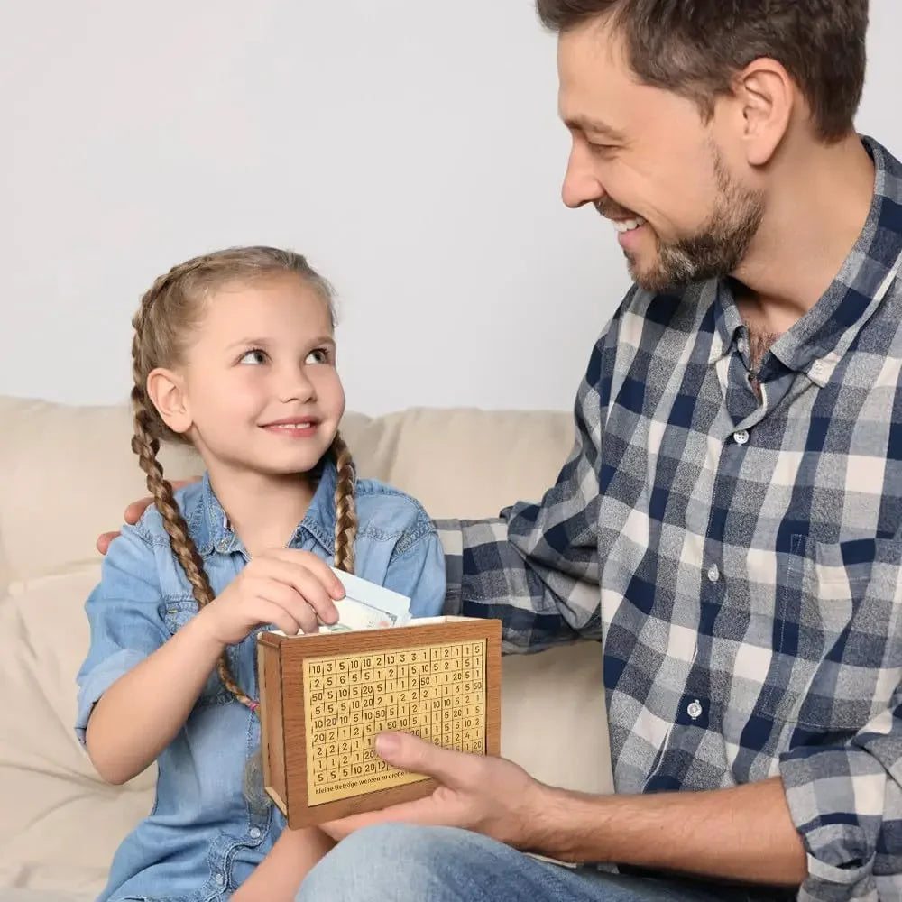 A smiling man is showing a young girl how to use a reusable wooden piggy bank for saving goals.