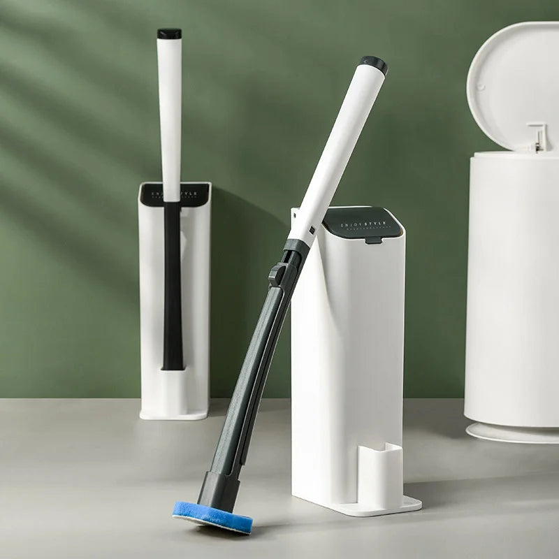 A long-handled disposable toilet brush is shown standing next to a white toilet brush holder against a green background.