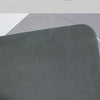 A close-up view of a dark gray diatomium mud floor mat with a rubber pattern on the bottom back.