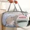 A person is holding a gray foldable mesh laundry basket filled with clothes, demonstrating its use for storage.
