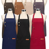 A display of various colored canvas aprons hanging on mannequins.