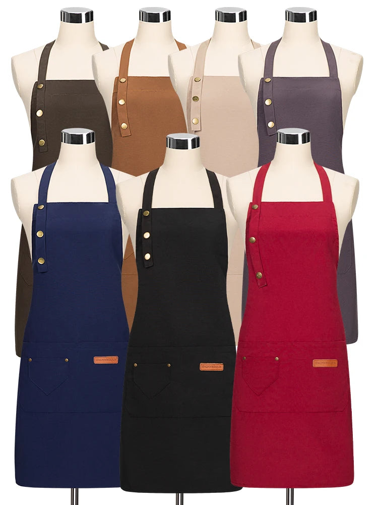 A display of various colored canvas aprons hanging on mannequins.