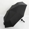 A black folding katana sword umbrella is shown open, angled downward against a white background.